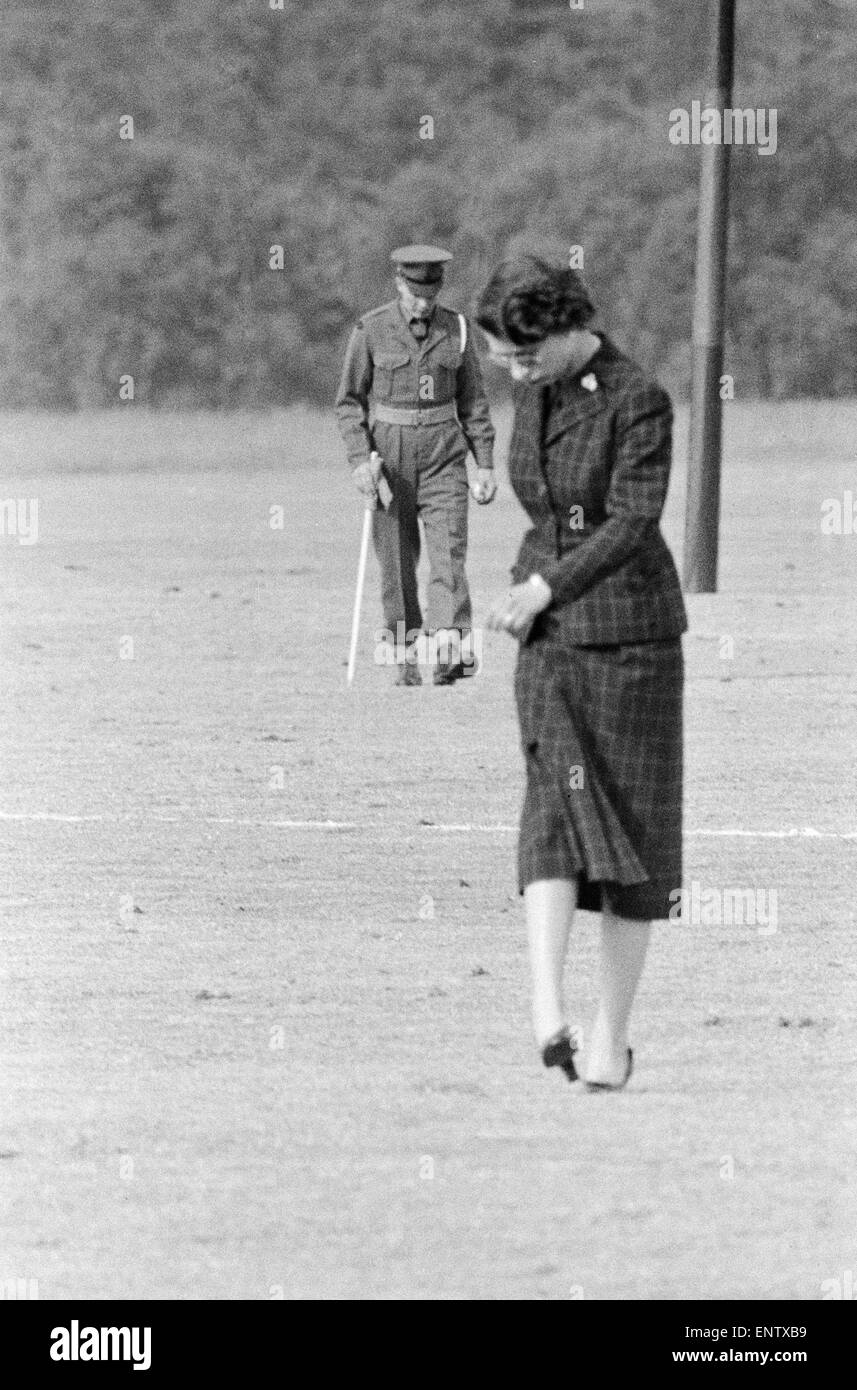Königin Elizabeth II Stempeln auf der Erde auf ein Polofeld Haushalt Brigaden Polo im Windsor Great Park Zuschauer Spiele gebeten, während einer Pause im Turnier über klumpigen Boden glatt helfen. Juni 1955 Stockfoto