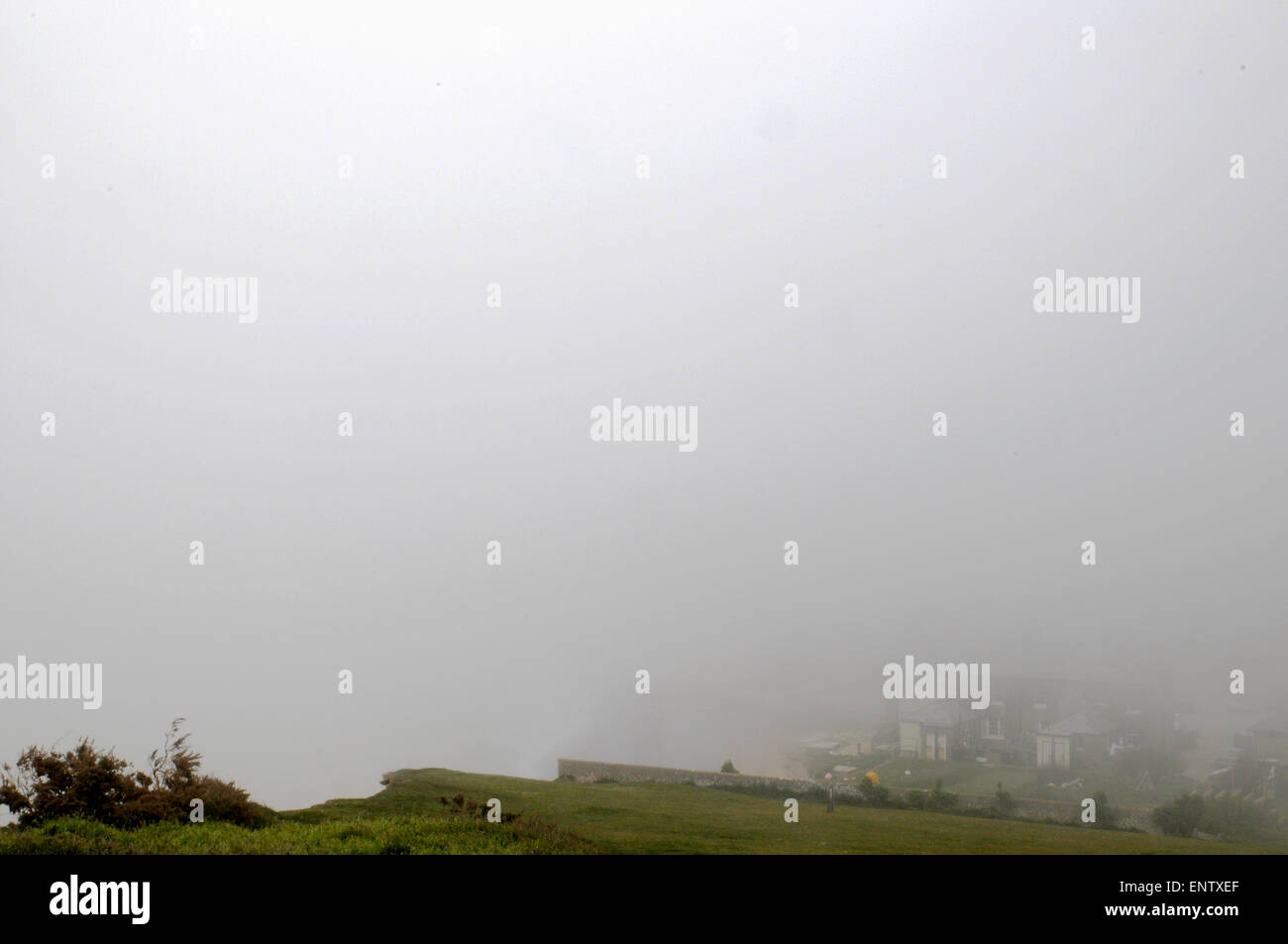 Eastbourne, East Sussex, Großbritannien. Mai 2015. Wetter in Großbritannien: Dichter Meeresnebel rollt entlang der Küste. Etwas mehr als eine Meile landeinwärts gibt es strahlende Sonneneinstrahlung.Cliffs Beyond Coastguard Cottages verdunkelt in Birling Gap Stockfoto