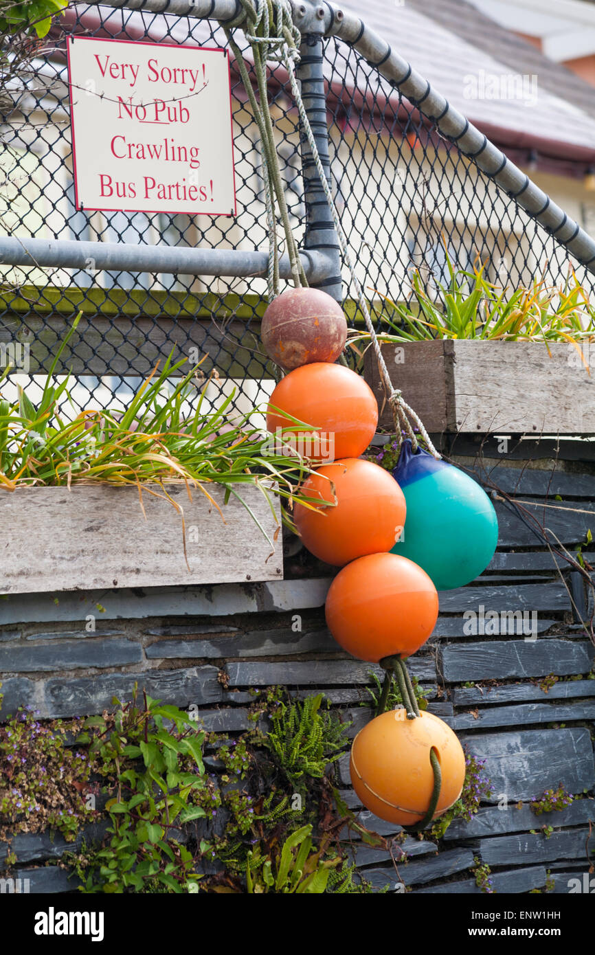 Schild und Angelbojen hängen vor dem Sloop Inn Pub in Porthgain, Pembrokeshire Coast National Park, Wales, Großbritannien im Mai Stockfoto