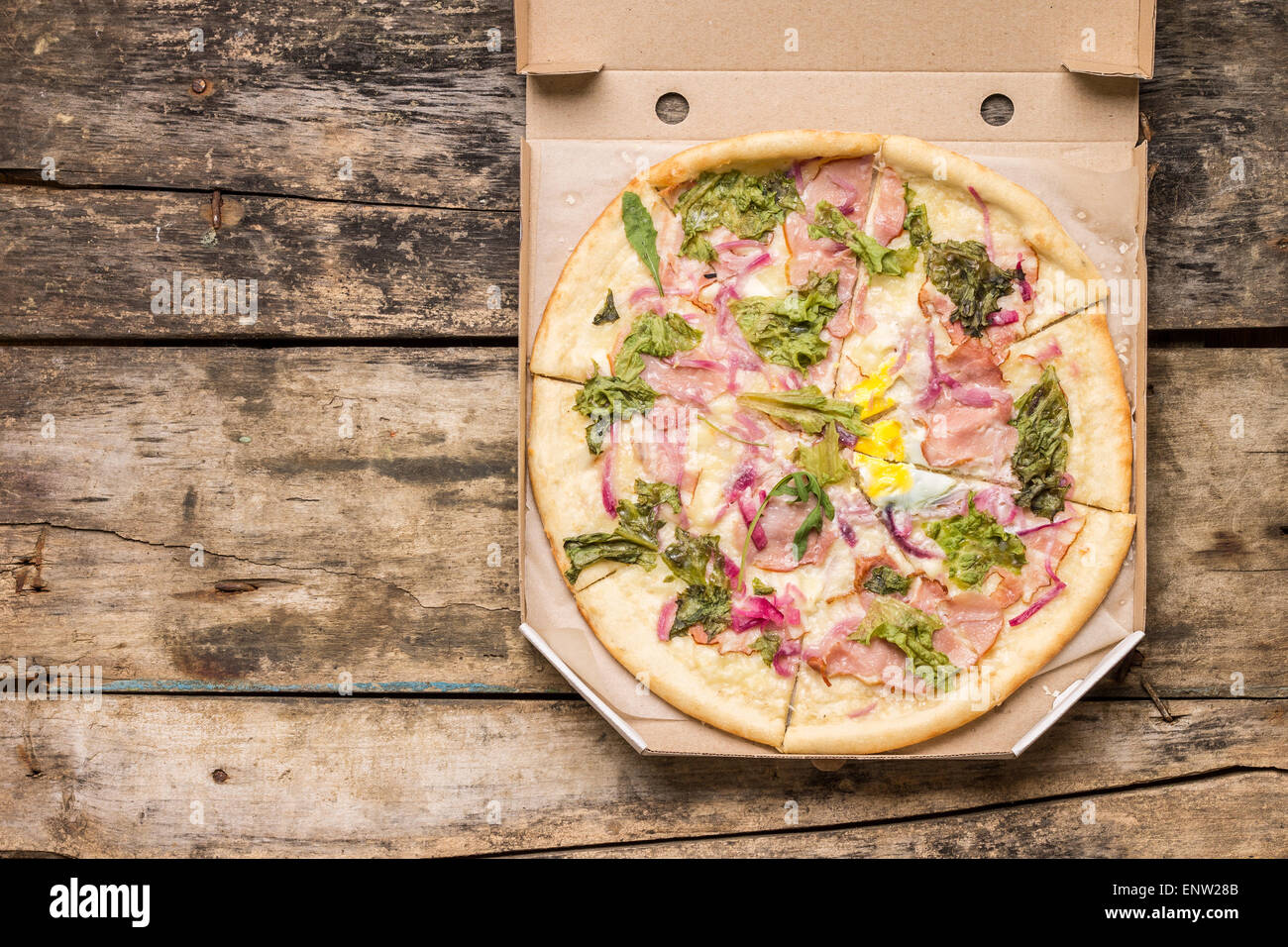 Restaurant Menü und Rezept Hintergrund. Leckere Pizza in Karton auf Holztisch. Stockfoto