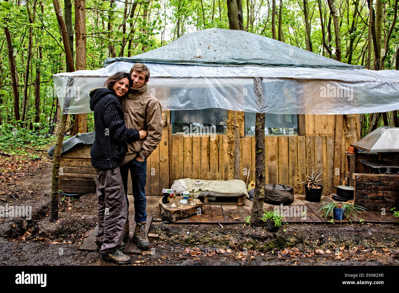 Andreia Gomez & Freund & das Haus baute sie über 9 Monaten von umgestürzten Bäumen & Holzpaletten in der "Öko-Dorf" Runnymede Stockfoto