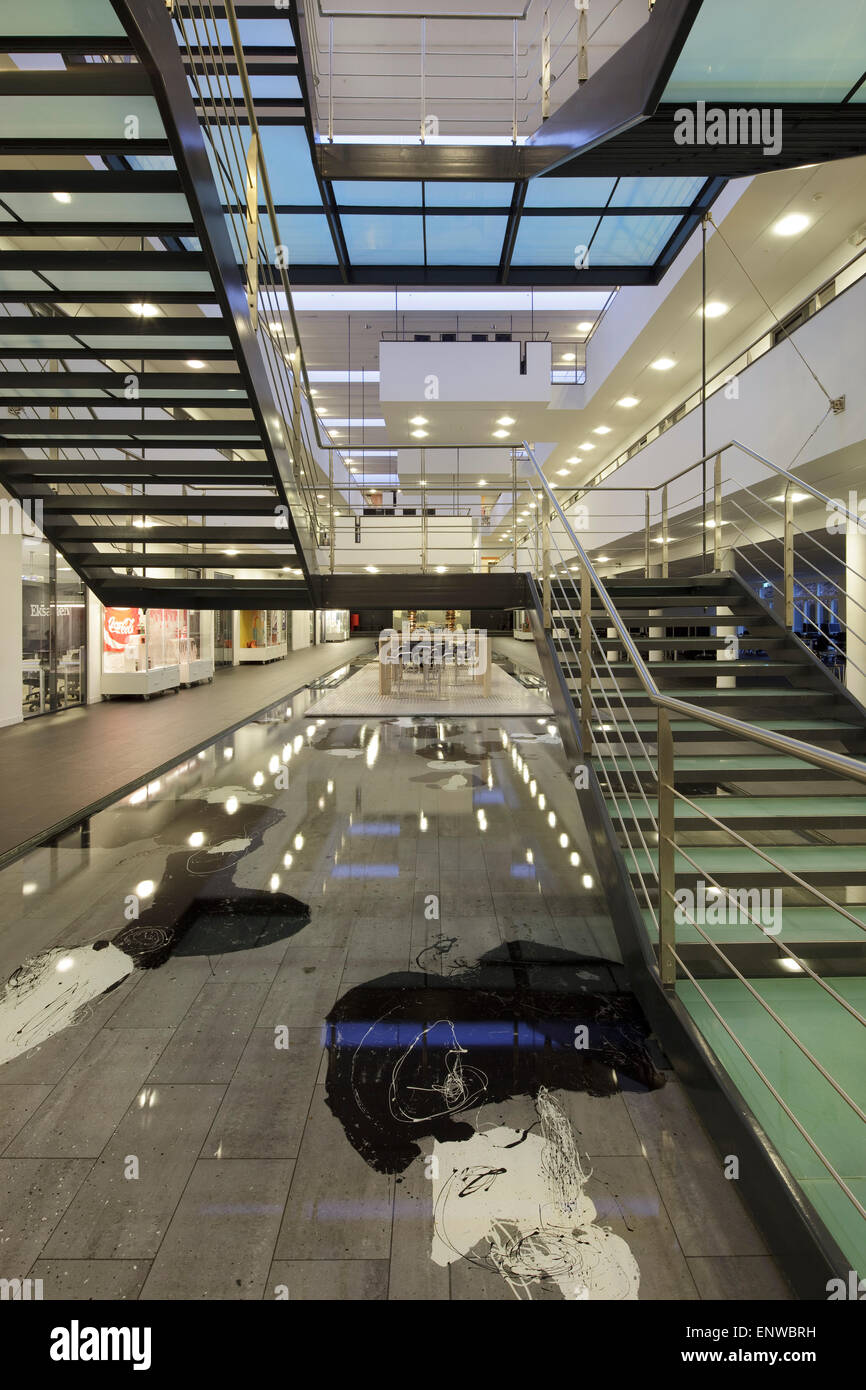 Atrium mit Wasserspiel und Haupttreppe gesehen vom Erdgeschoss in der Abenddämmerung. IBC-Kolding-Campus, Kolding, Dänemark. Architekt: sc Stockfoto