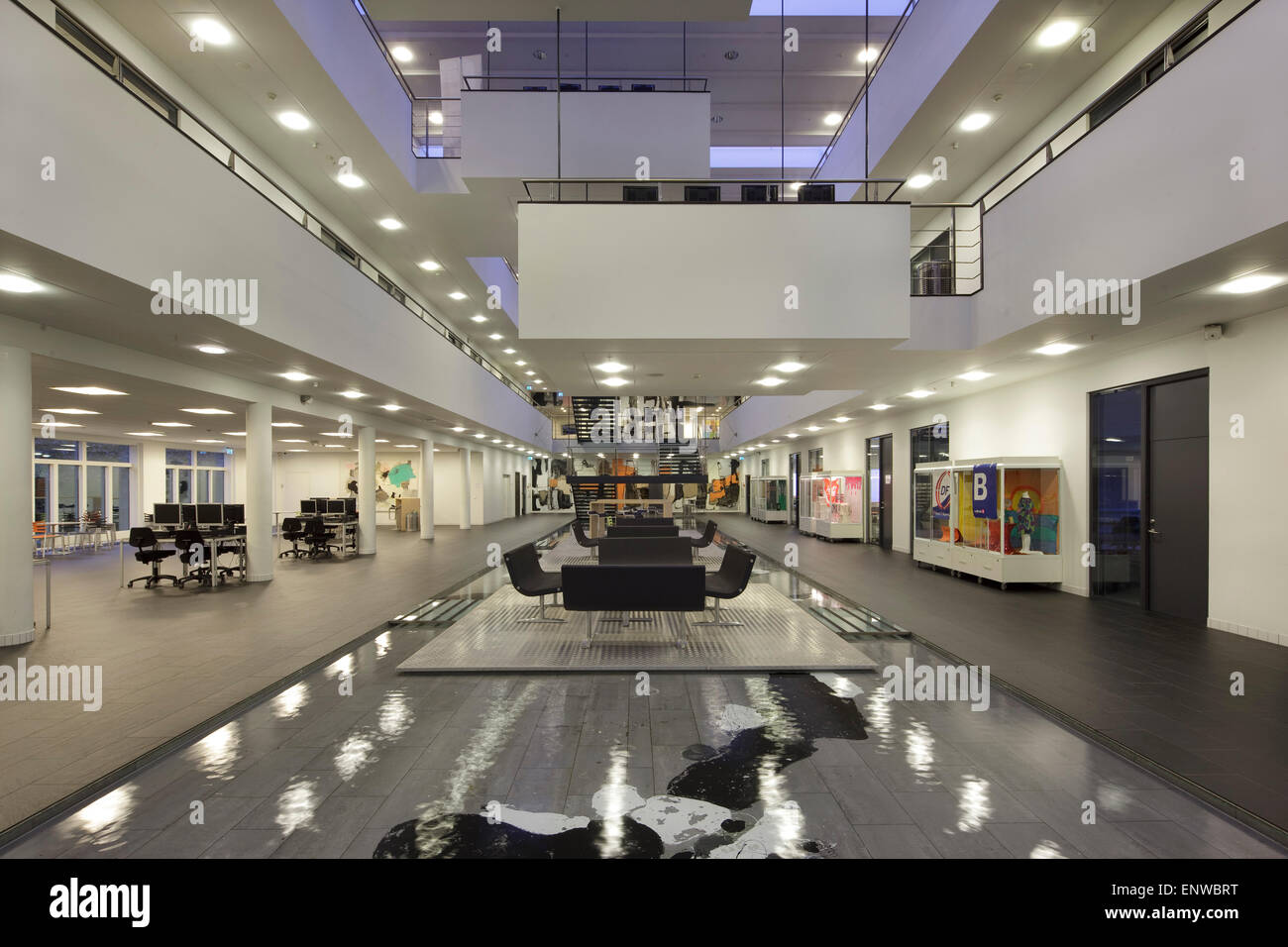 Atrium mit Wasserspiel und Meeting-Bereich vom Erdgeschoss in der Dämmerung zu sehen. IBC-Kolding-Campus, Kolding, Dänemark. Architekt: Schm Stockfoto
