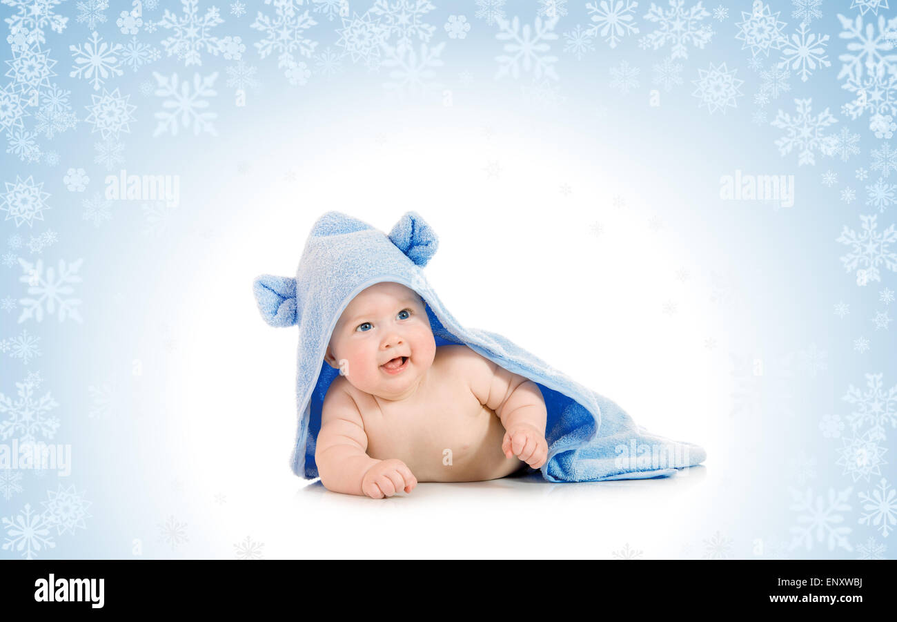 Kleinen lächelnden Baby mit einem Handtuch auf verschneiten Hintergrund Stockfoto