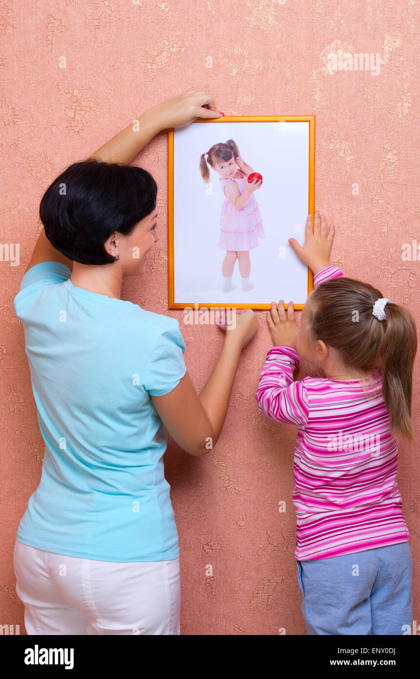 Frau mit kleinen Mädchen legen Sie auf ein Bild (Porträt von demselben Mädchen) Stockfoto