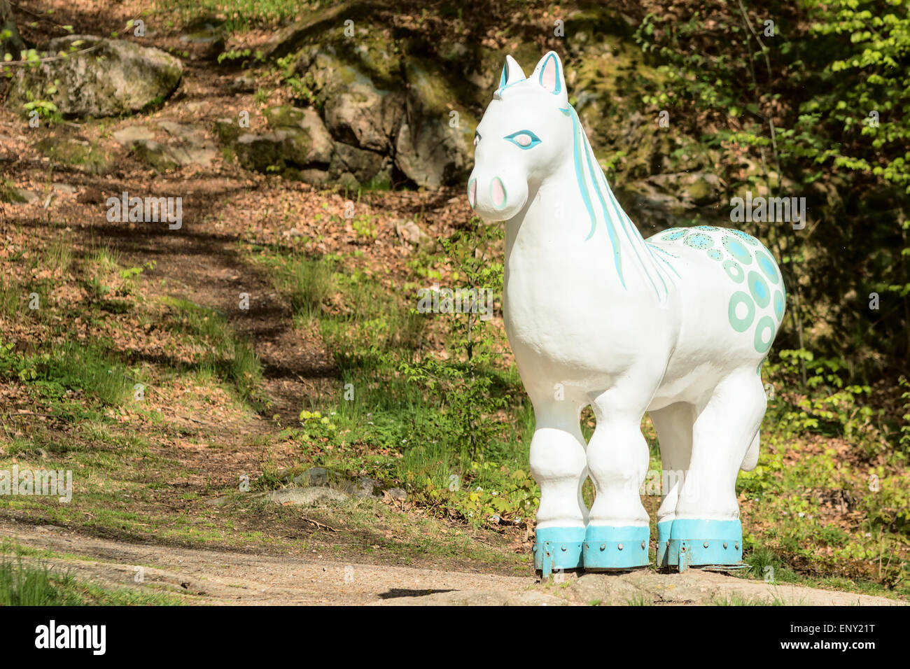 Ronneby, Schweden - 11. Mai 2015: Leben Größe weißen Bach Pferd Statue auf einem Felsen im Wald in der Nähe von einem kleinen Fluss. Das Bach-Pferd wird geglaubt, um die Seele des Flusses (Wassergeist) sein. Stockfoto