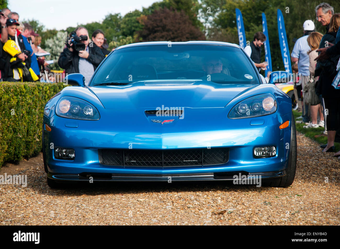 Front-Endansicht auf einen blauen Spätmodell amerikanischen Corvette Sportwagen auf einem Kiesweg mit Fahrer und mehrere auf Zuschauer in der Nähe. Stockfoto