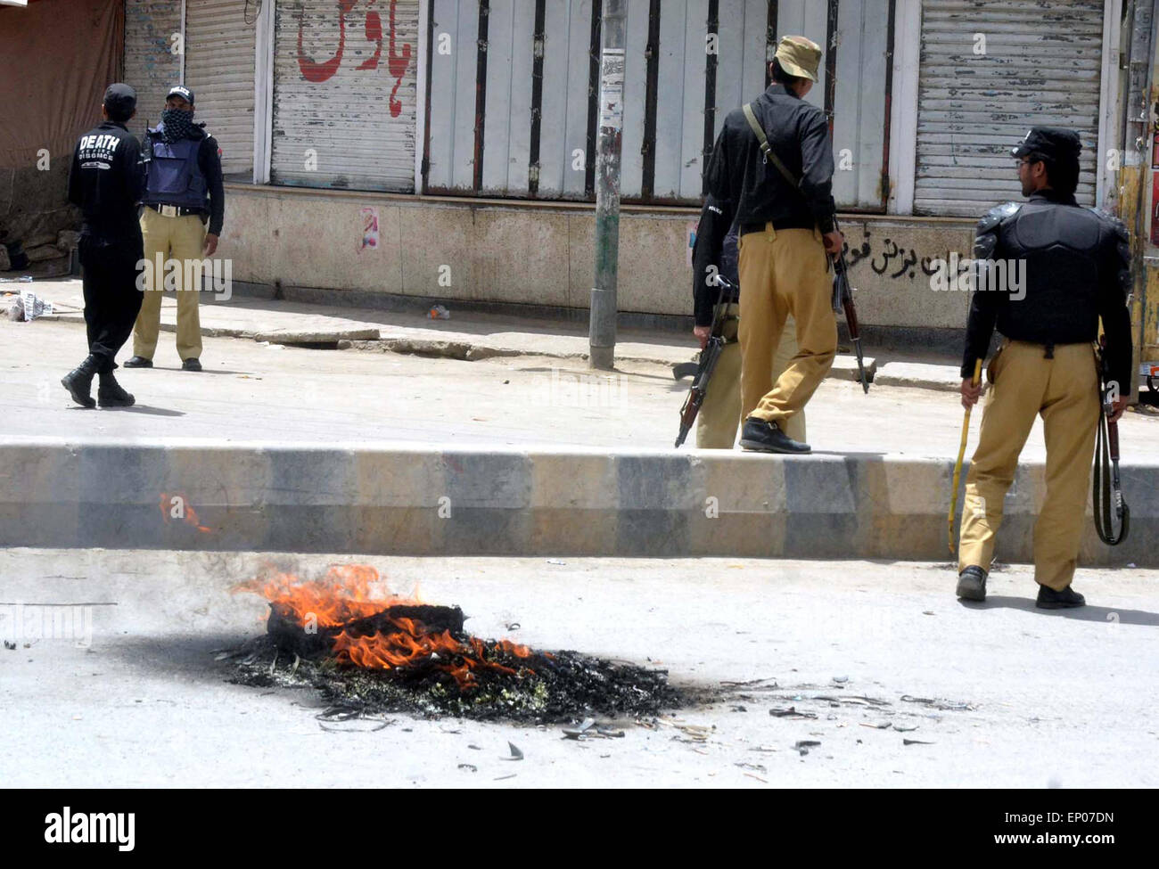 Angehörigen der verletzten Opfer des Brand einfallenden Opfer bei Kasi Road block brennen Straßenreifen wie sie gegen Unruhen Law &amp; Order Situation während der Demonstration am Mezan Chowk in Quetta auf Dienstag, 12. Mai 2015 protestieren. Stockfoto