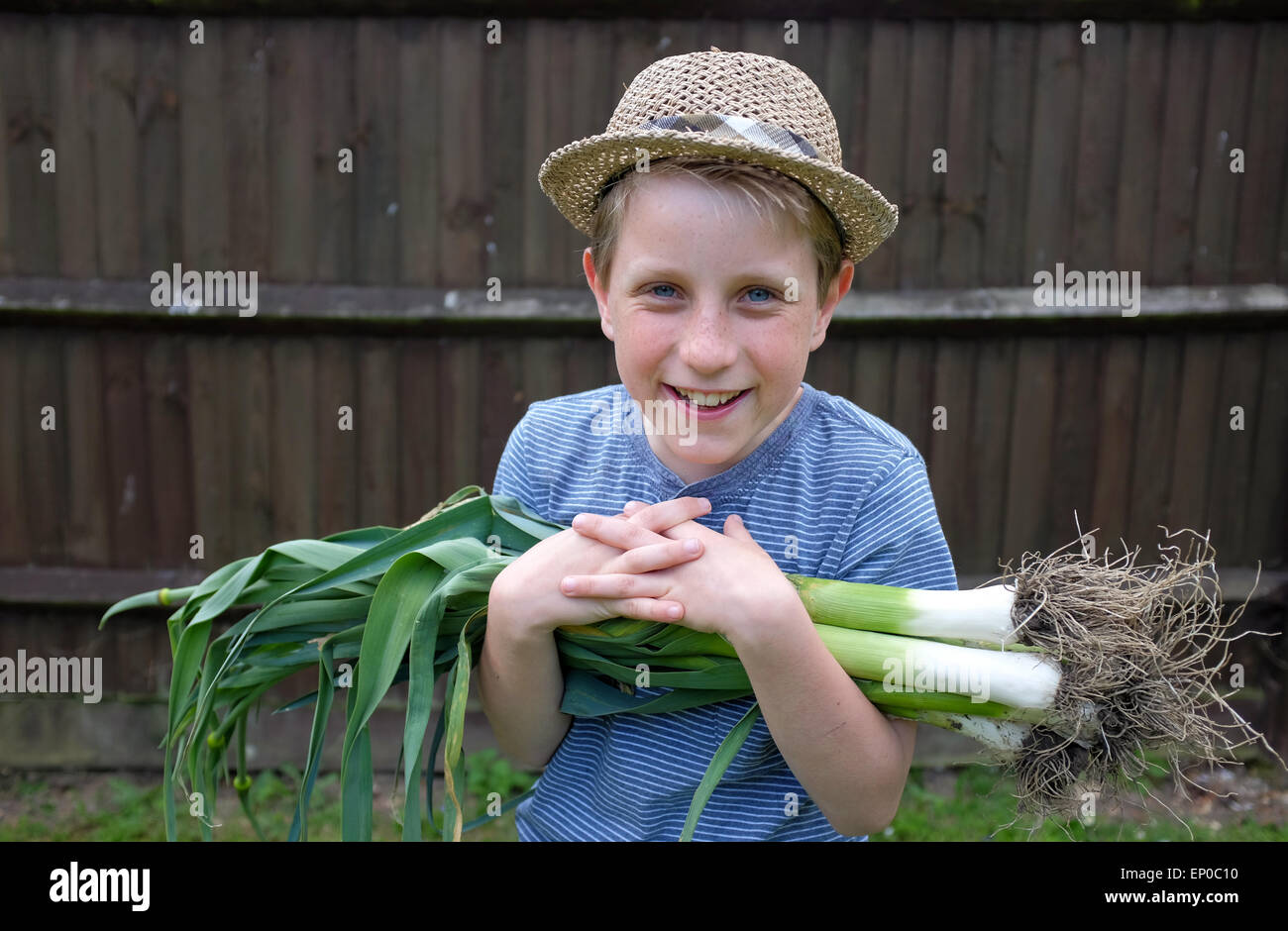 Ein fröhlicher Junge mit frischen Bio Lauch aus dem Garten gepflückt gewachsen Stockfoto