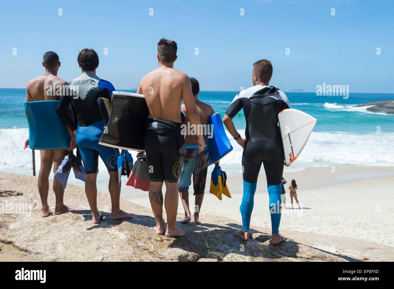 RIO DE JANEIRO, Brasilien - 24. März 2015: Gruppe von jungen brasilianischen Surfer stehen mit Blick auf die Wellen an der Praia Diabo. Stockfoto