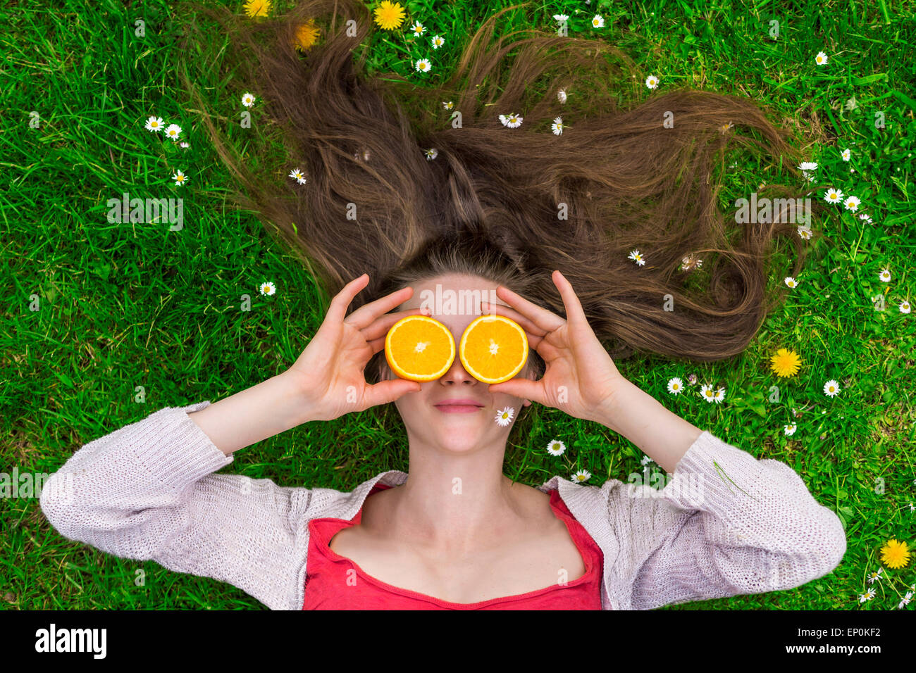 Dame mit Orangen Verlegung auf Rasen Stockfoto