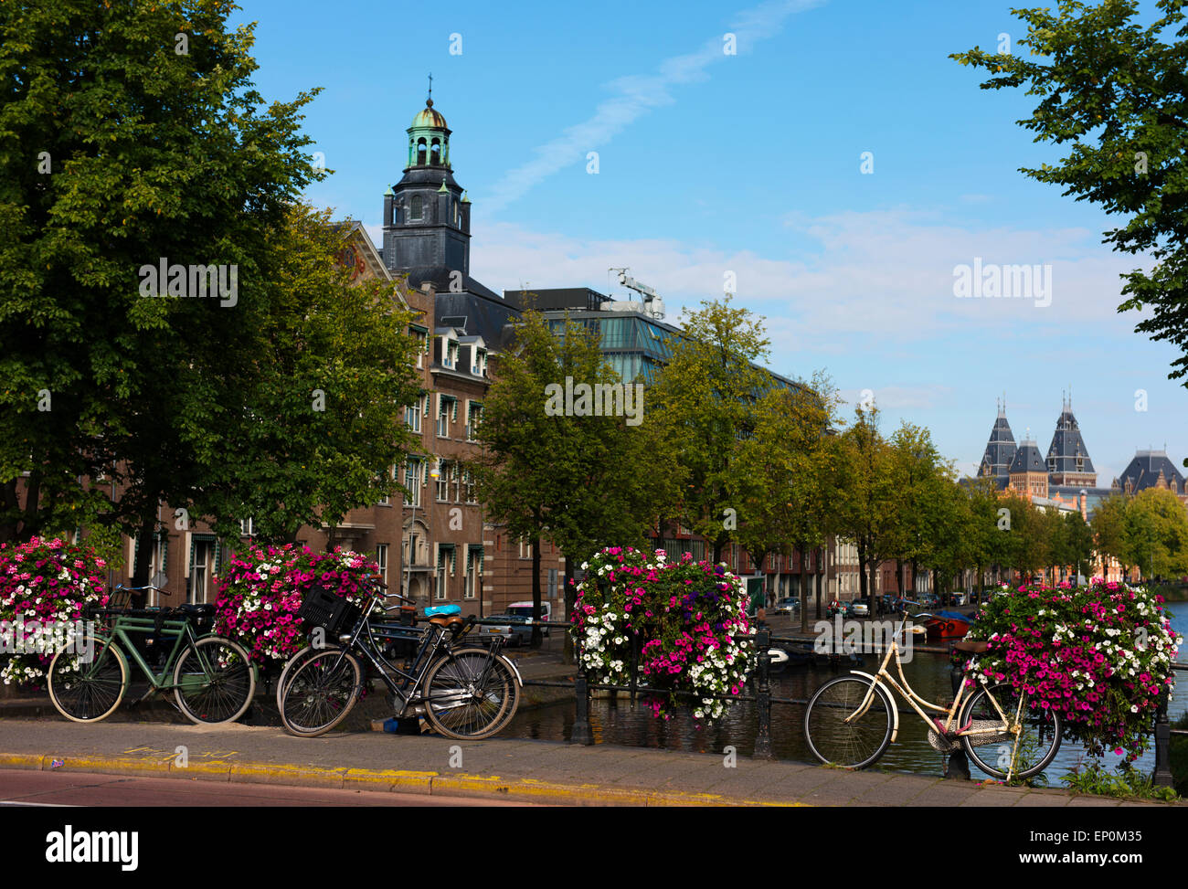 Fahrräder auf einer Brücke mit Blumen in Amsterdam. Stockfoto