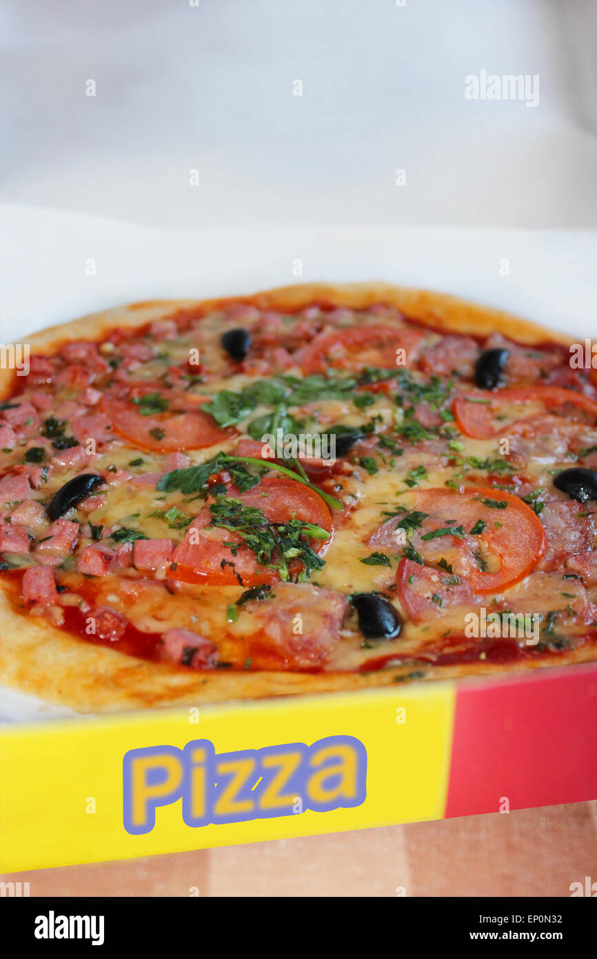 Pizza mit einer leckeren Füllung in der Lieferbox Stockfoto