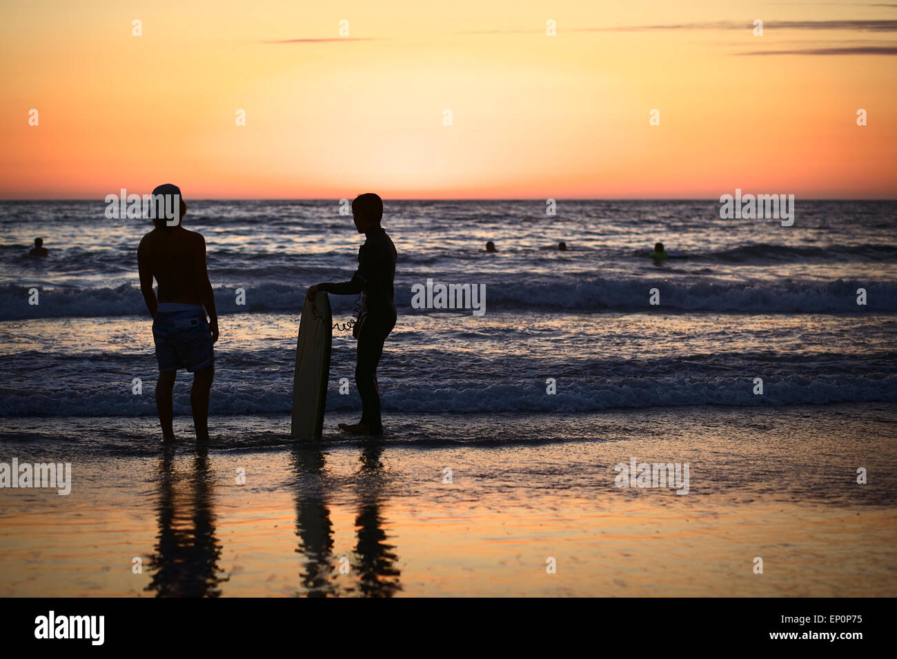 Junge Menschen stehen am Ufer am Cavancha Beach bei Sonnenuntergang in Iquique, Chile Stockfoto