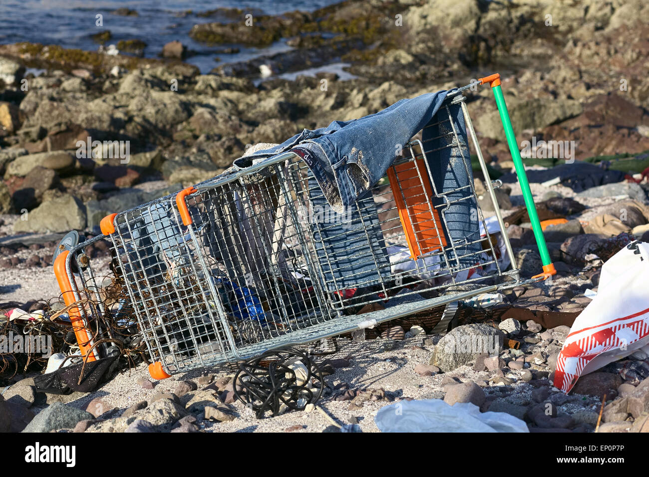 Verlassene Einkaufswagen mit ein paar Jeans oben am Strand in Iquique, Chile Stockfoto