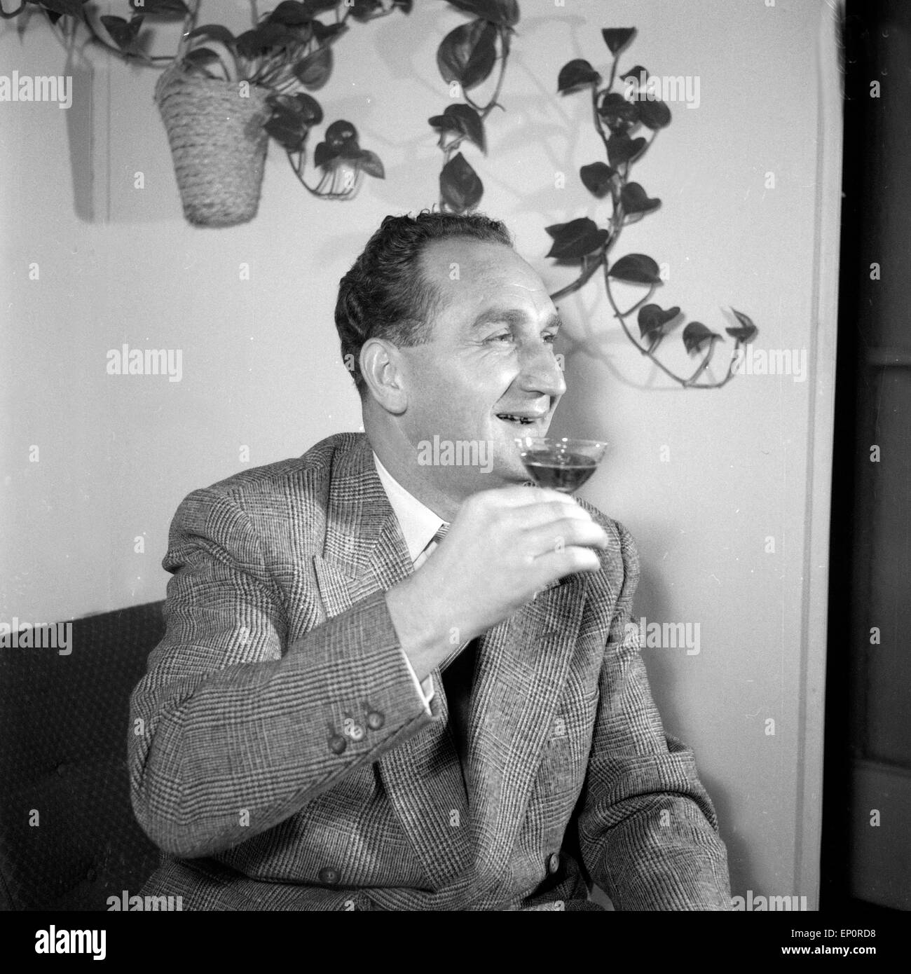 Deutscher Komponist und Zitherspieler Alfons Bauer genießt einen Cognac, Hamburg 1955. Deutsche Komponist und Zither Spieler Alfo Stockfoto