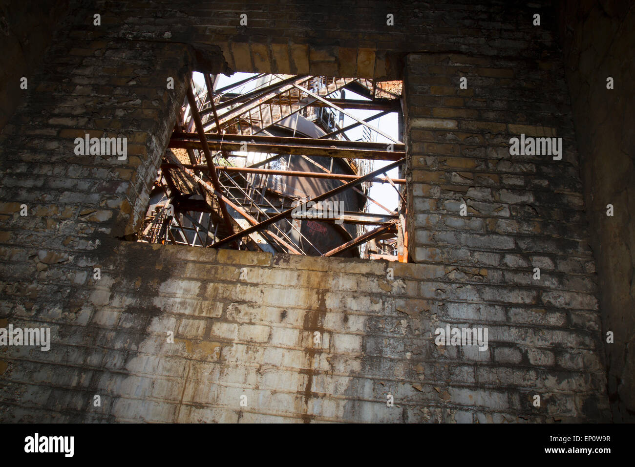 Rostendem Stahl Hochofen durch th Fenster eines verfallenen Gebäudes gesehen. Stockfoto
