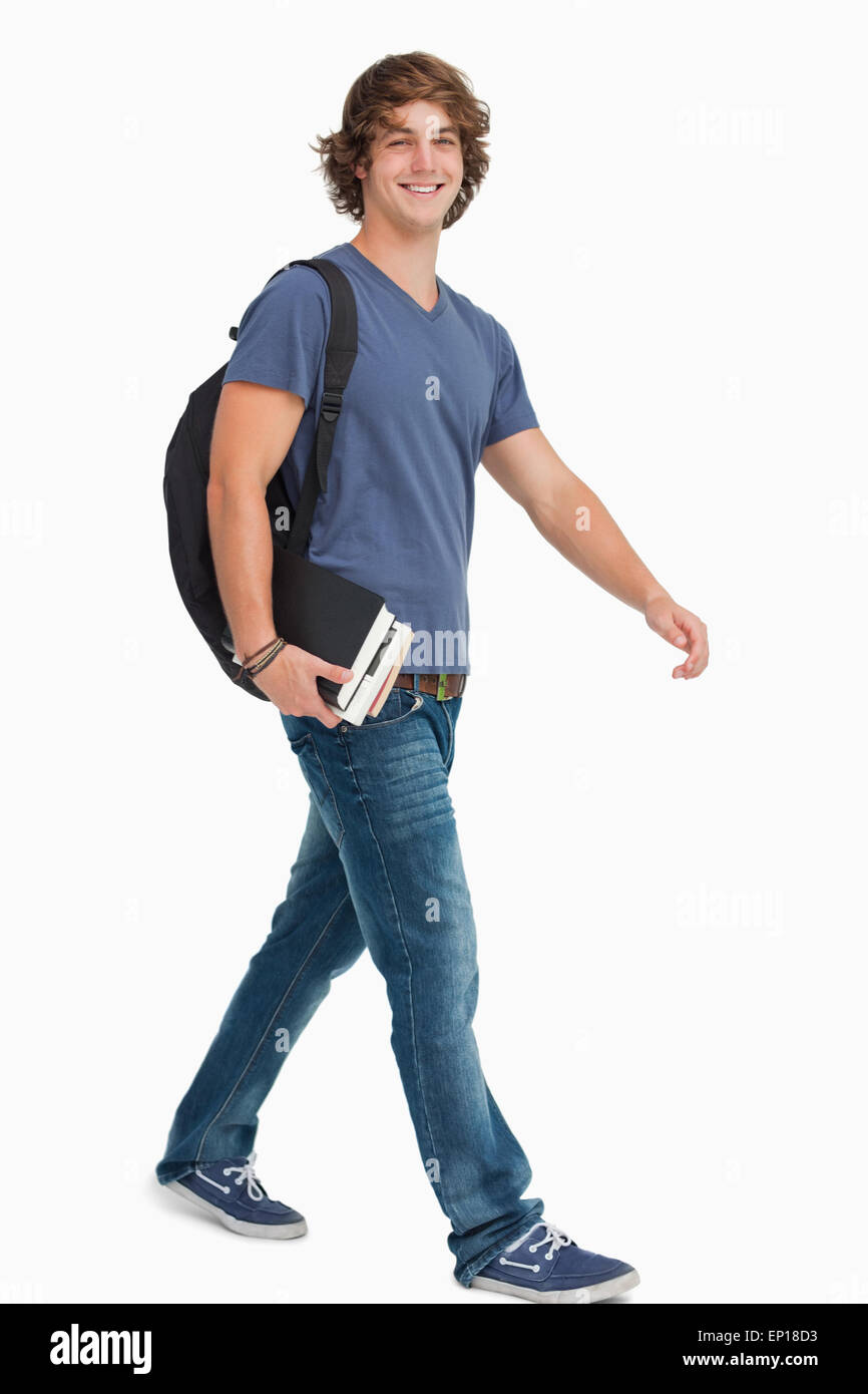 Männliche Schüler mit einem Rucksack mit Büchern während des Gehens Stockfoto Männliche Schüler mit einem Rucksack mit Büchern während des Gehens Stockfoto