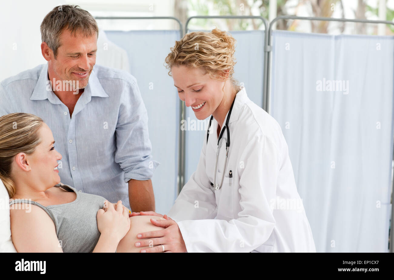 Schwangere Frau mit ihrem Ehemann die Krankenschwester anhören Stockfoto