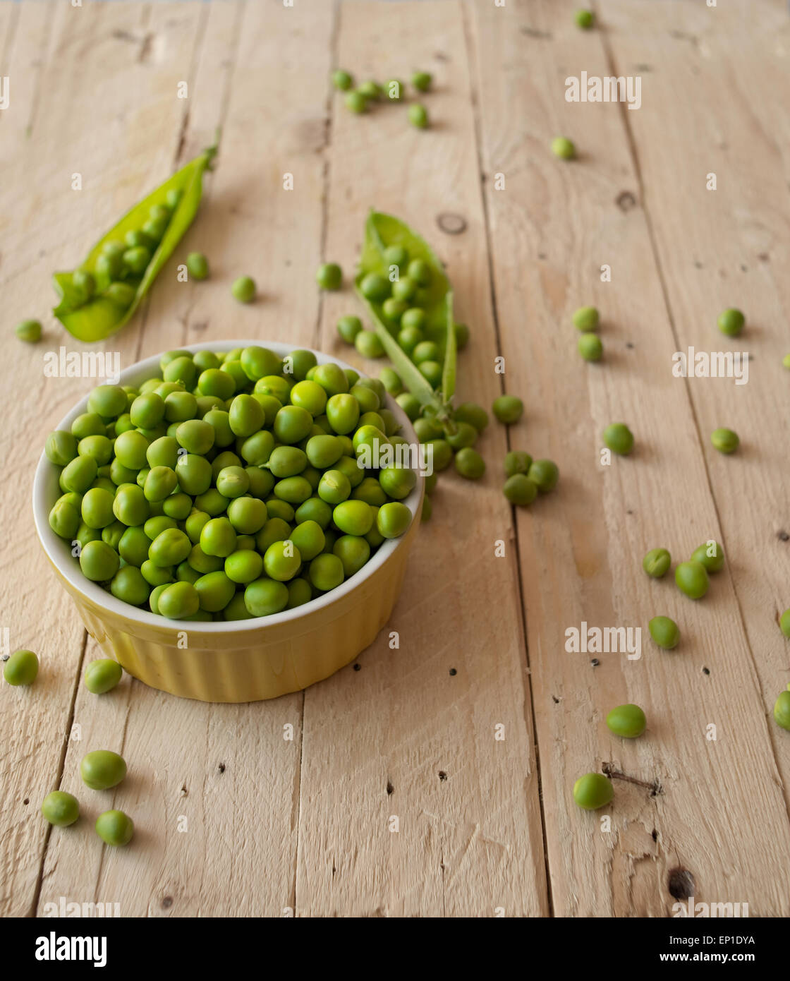 Ökologische frische grüne Erbsen Hülsen in einem rustikalen Holztisch. Stockfoto