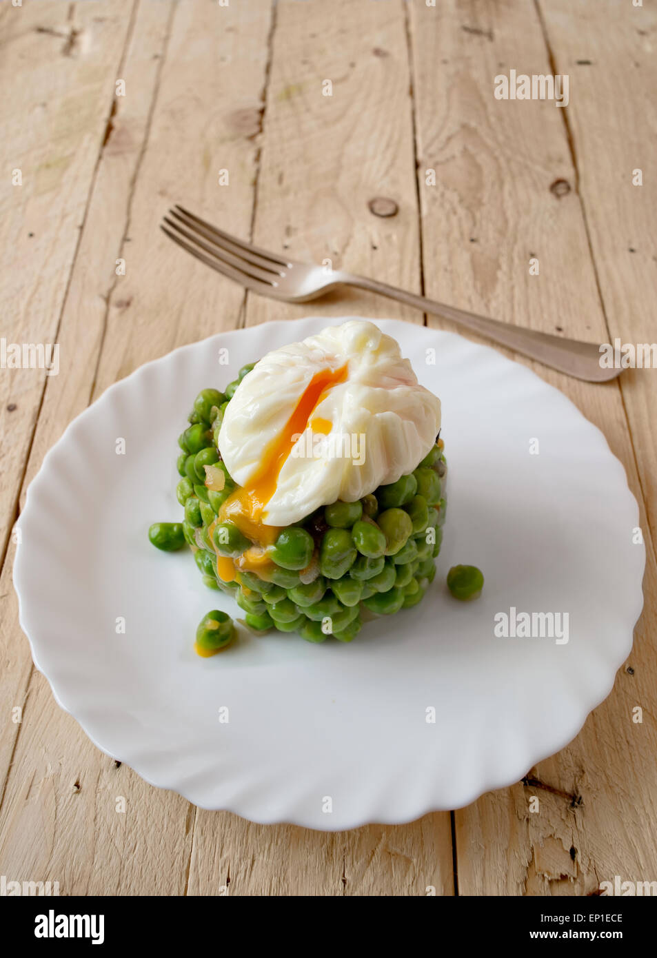 Ökologische frische grüne Erbsen Hülsen mit weich gekochtes Ei in einem rustikalen Holztisch. Stockfoto