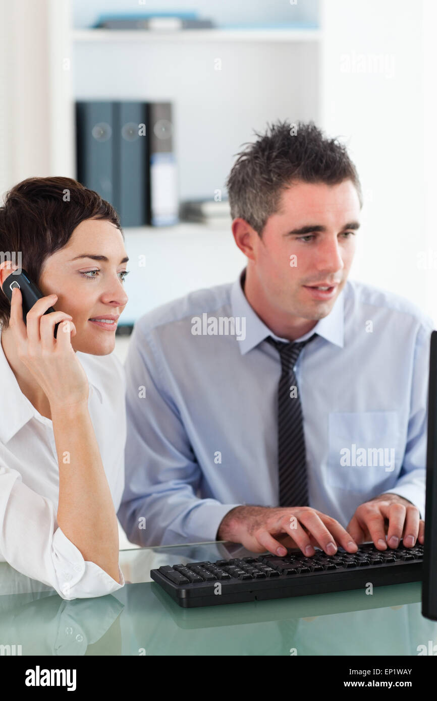 Porträt einer Frau telefonieren, während ihre Kollegin eine c verwendet Stockfoto