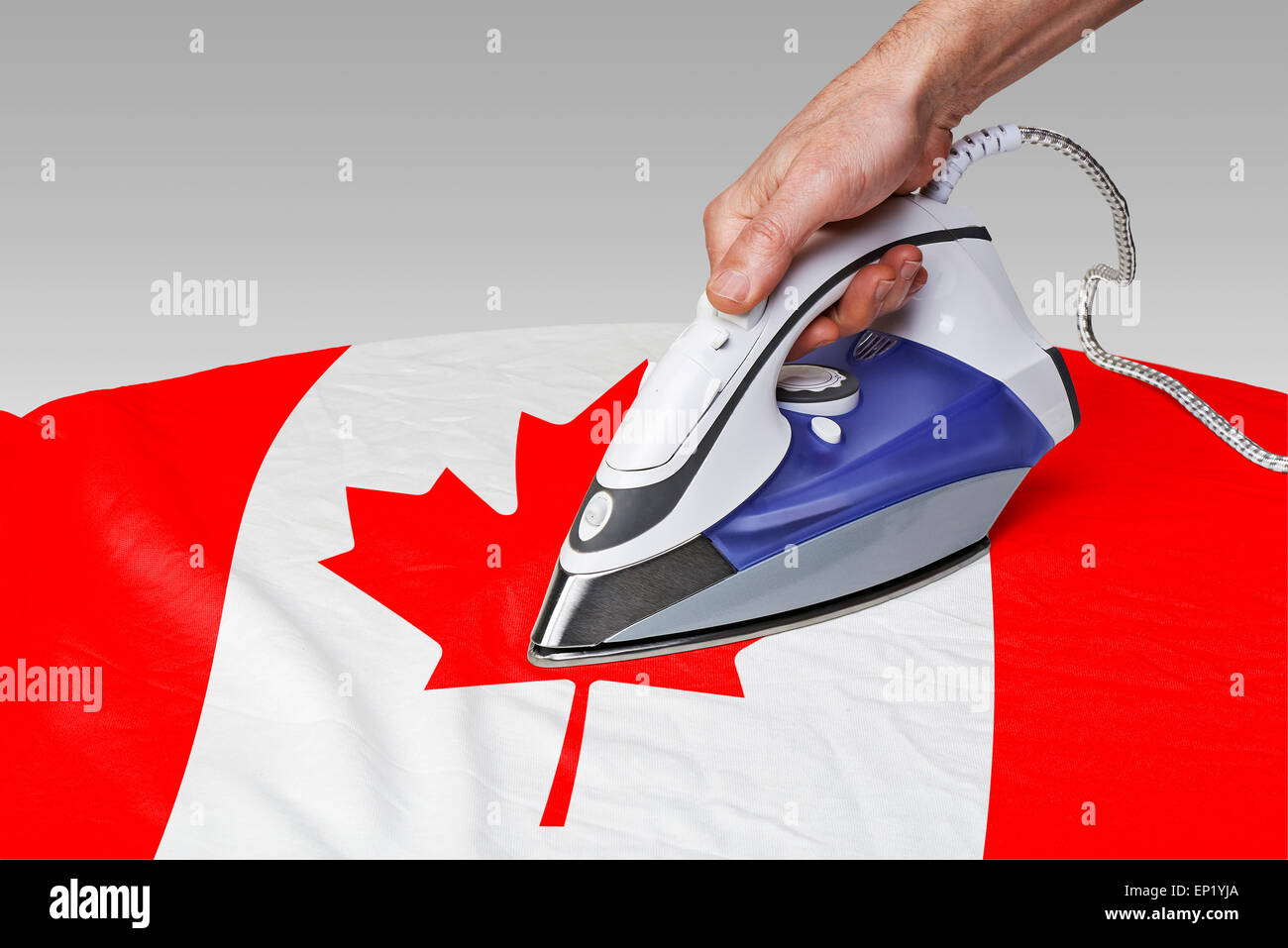 Dampfbügeleisen für glätten Sie die Falten der Flagge von Kanada Stockfoto