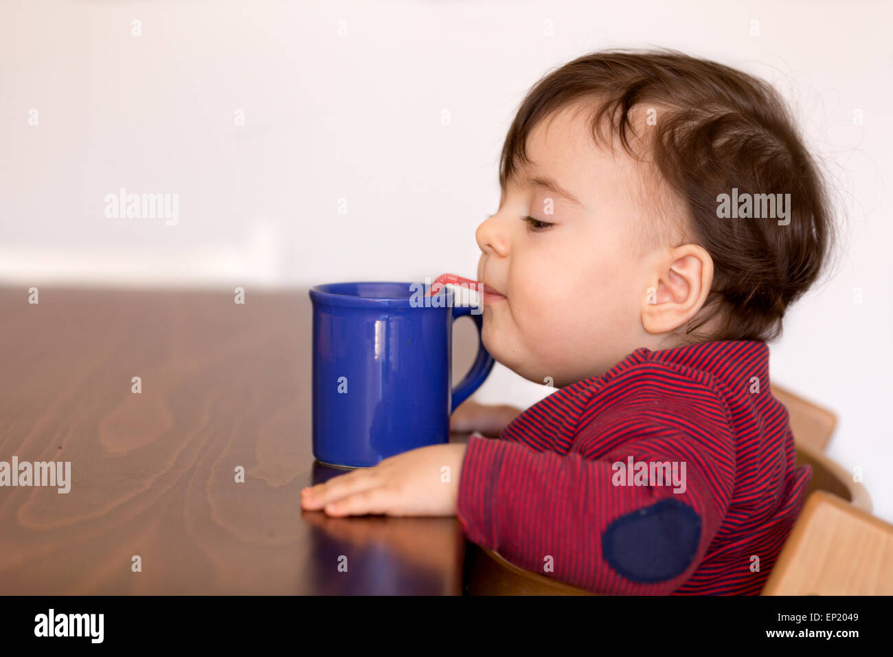 Junge Trinkwasser mit Stroh Stockfoto