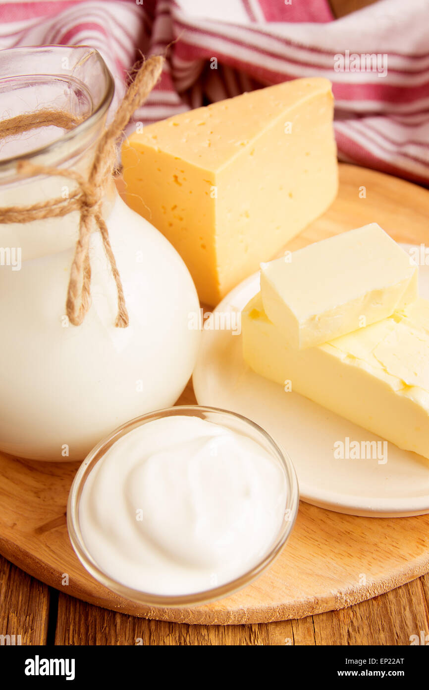 Milchprodukte - Milch, Käse, Butter, Sauerrahm über Holztisch Stockfoto