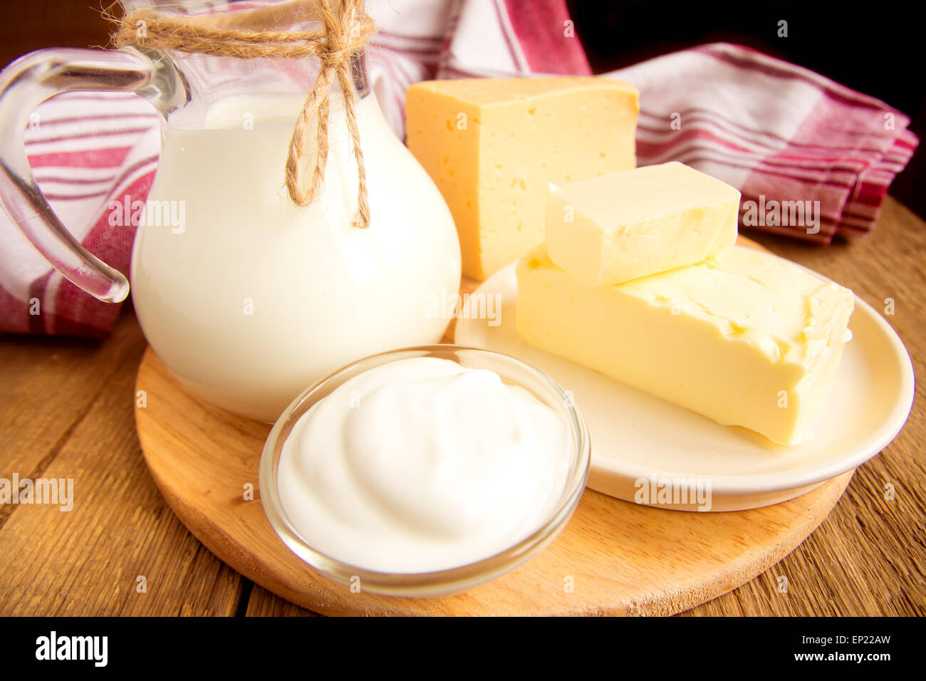 Milchprodukte - Milch, Käse, Butter, Sauerrahm über Holztisch Stockfoto