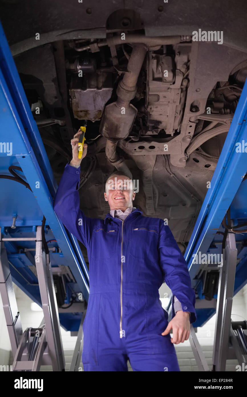 Lächelnde Mechaniker repariert ein Auto mit einem verstellbaren Zangen Stockfoto