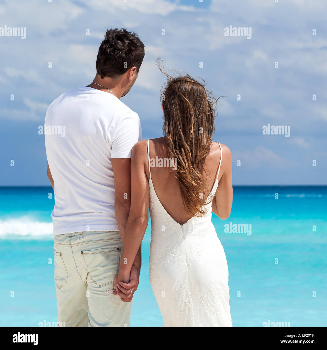 Frisch verliebt am Strand zum Meer suchen und halten ihre Hände Stockfoto