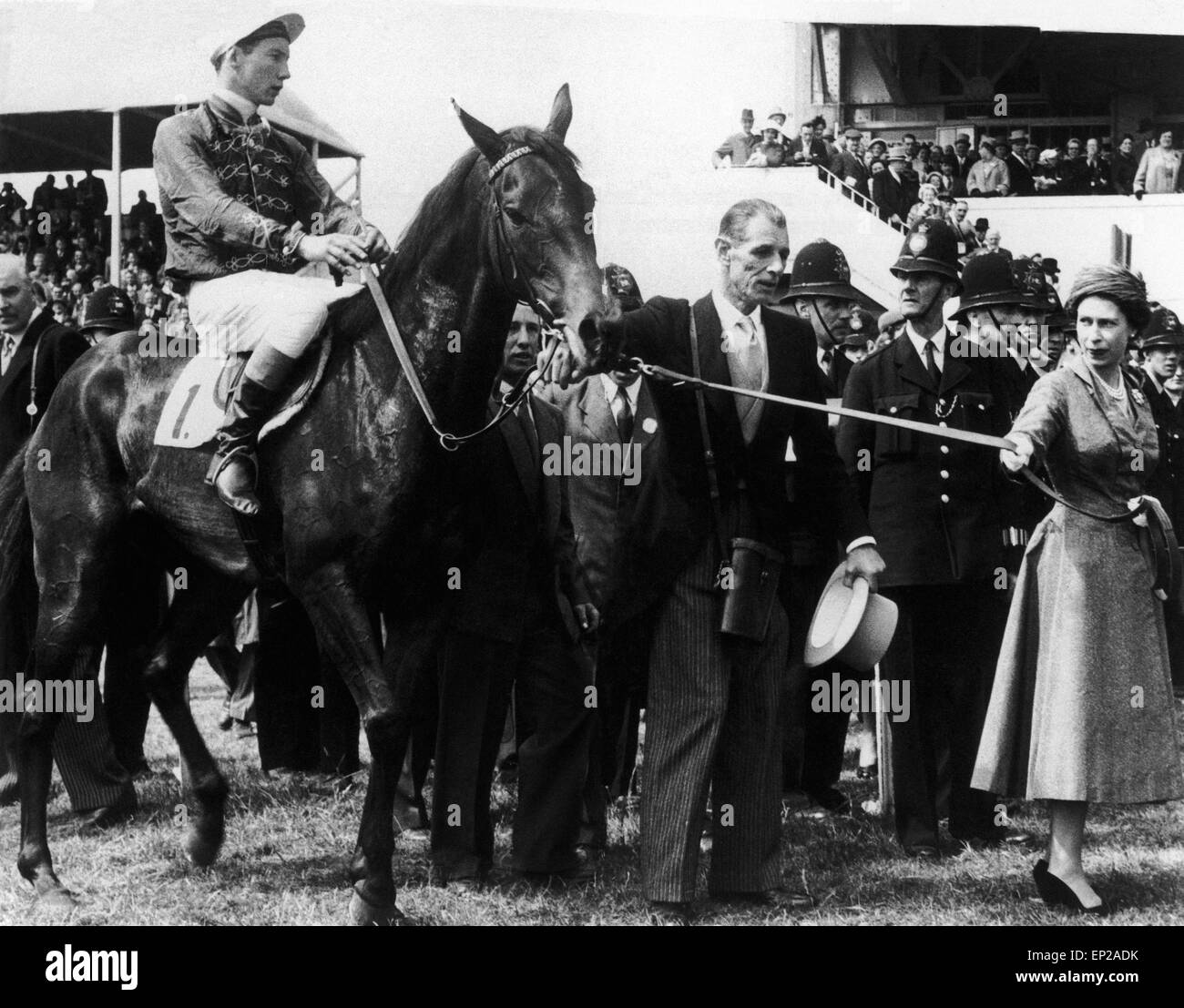 Ihre Majestät Königin Elizabeth II führt in ihrem Pferd "Carrogan" in das UN-satteln Gehäuse nach dem Pferd Sieg beim Rennen in Epsom Oaks. 7. Juni 1957. Stockfoto