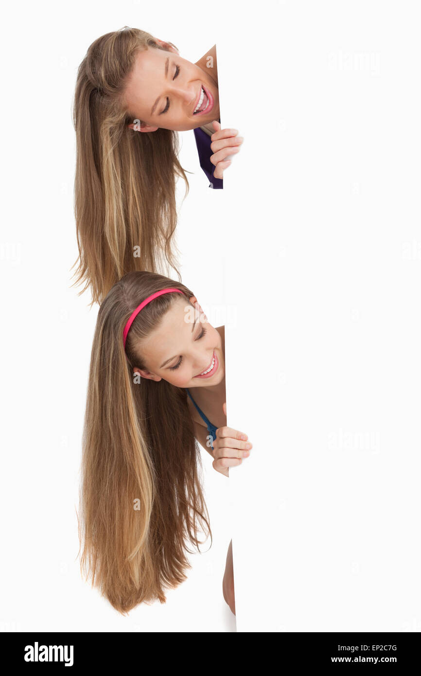 Nahaufnahme von zwei Lächeln lange Haare Studenten hinter ein leeren Zeichen Stockfoto