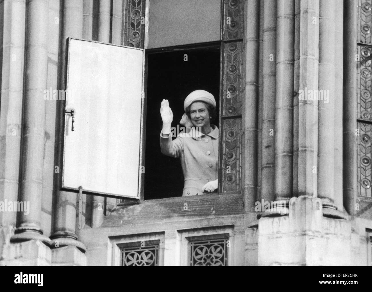 Die Königin besucht Manchester. 'Hallo Manchester' The Queen verleiht den wartenden Massen unten eine königliche Welle aus dem ersten Stock Fenster der Manchester Town Hall. 20. Juni 1977. Stockfoto