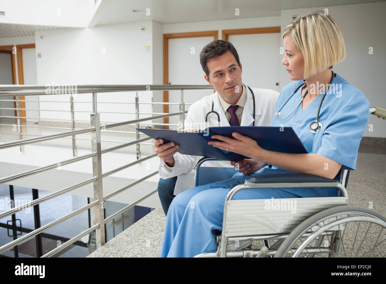 Arzt und Krankenschwester im Rollstuhl studieren Ordner Stockfoto