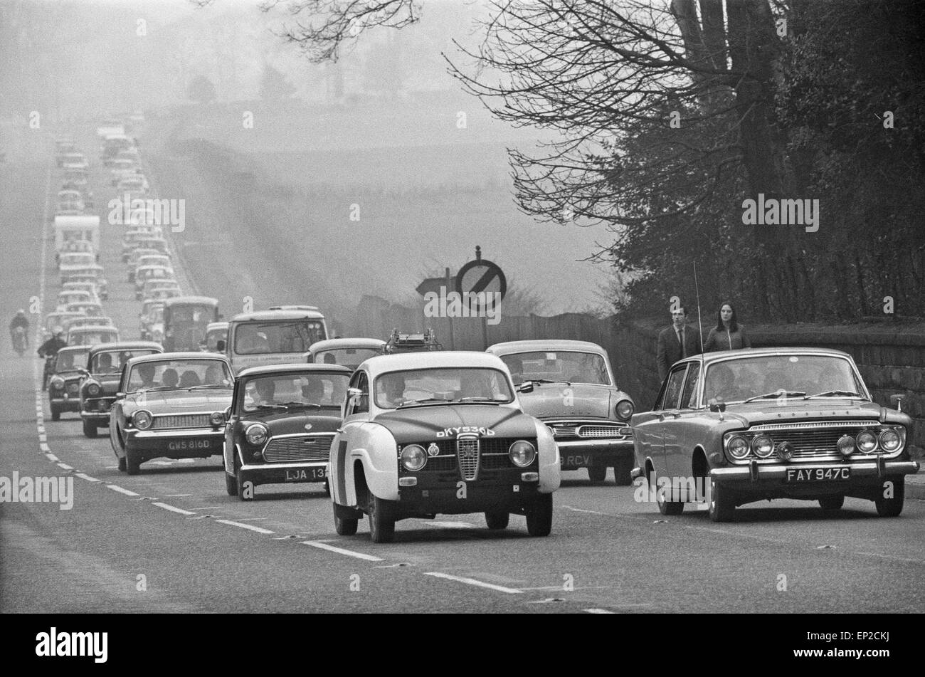 Fußgänger betrachten über den Verkehr entlang der A556 in Richtung Manchester, aufgebaut wie Urlauber nach Hause von North Wales, nach einem sizzling Ostern Bank Holiday Montag gesetzt. 7. April 1969. Stockfoto