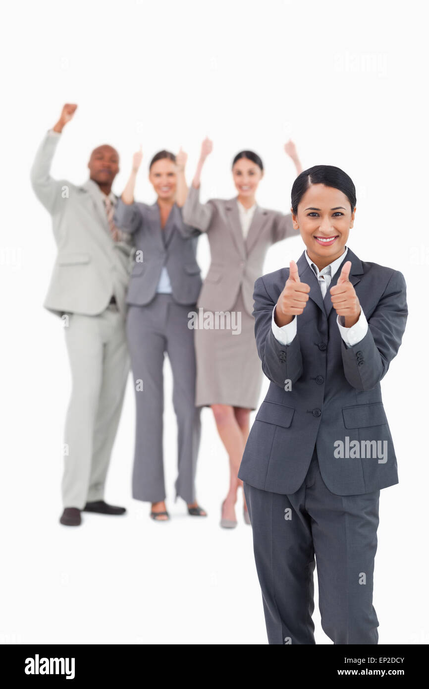 Verkäuferin mit Jubel Team hinter ihr geben Daumen hoch Stockfoto