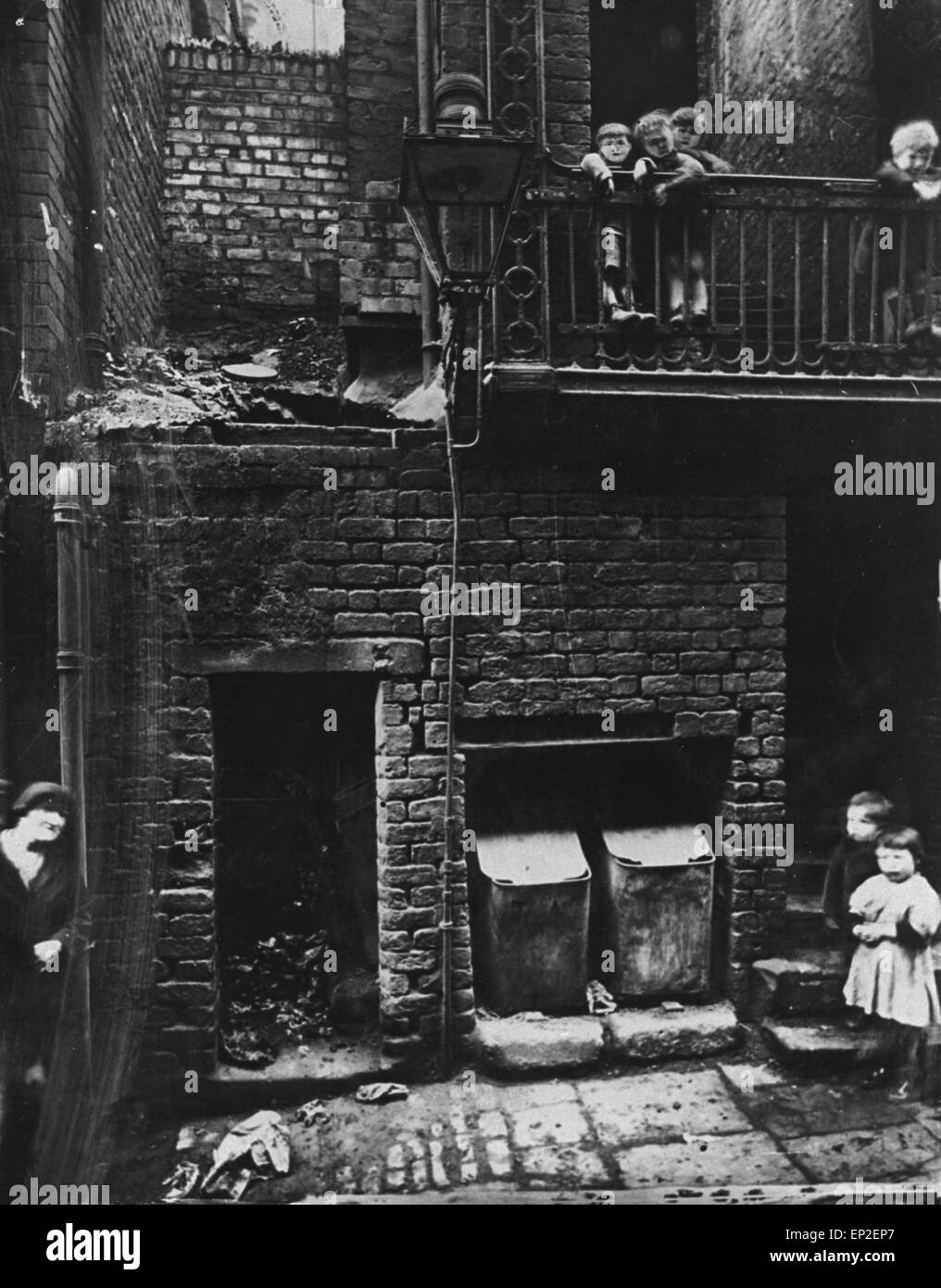 Eine Frau und sechs Kinder, einige auf dem Balkon, in einer Liverpool Slum-Szene. Die Gesichter der drei Kinder zusammen gruppiert, auf dem Balkon haben deutlich wurden retuschiert, ihre Funktionen Definition hinzufügen. 2. November 1933 Stockfoto