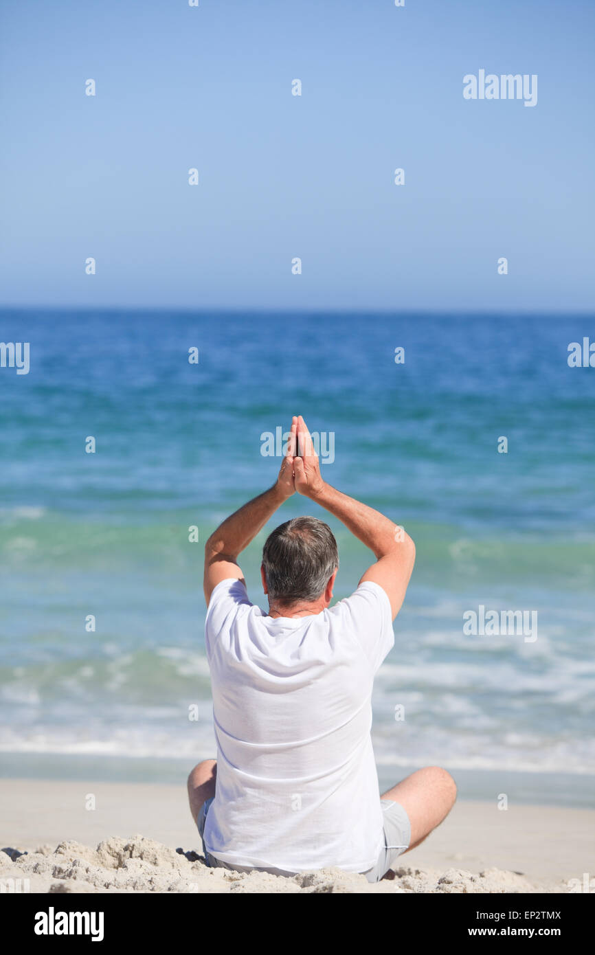 Mann tut seine Strecken am Strand Stockfoto