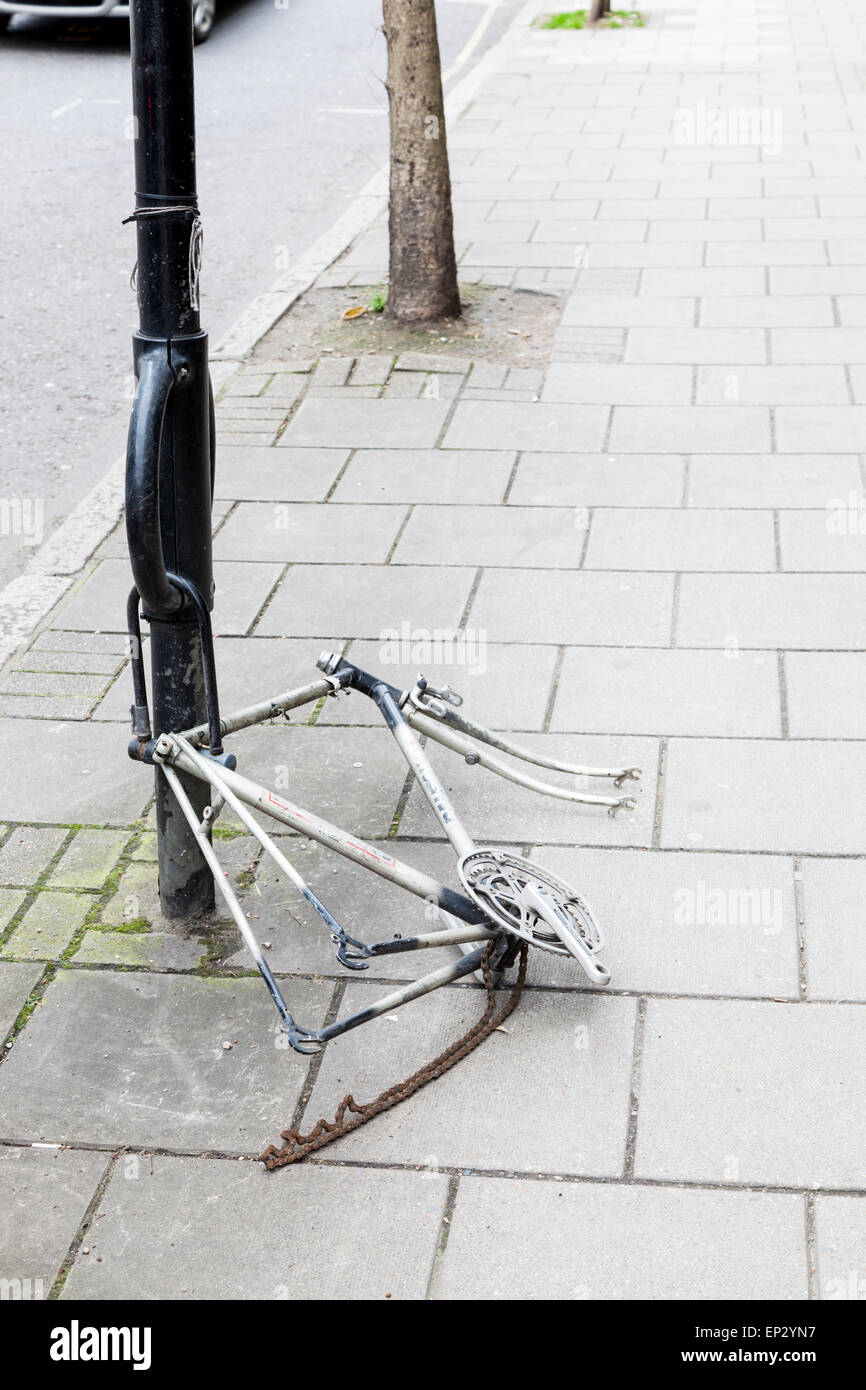 Fahrrad Diebstahl. Räder, Lenker, Pedale, Sitz und andere Elemente aus einem gesperrten Fahrrad gestohlen, London, England, Großbritannien Stockfoto