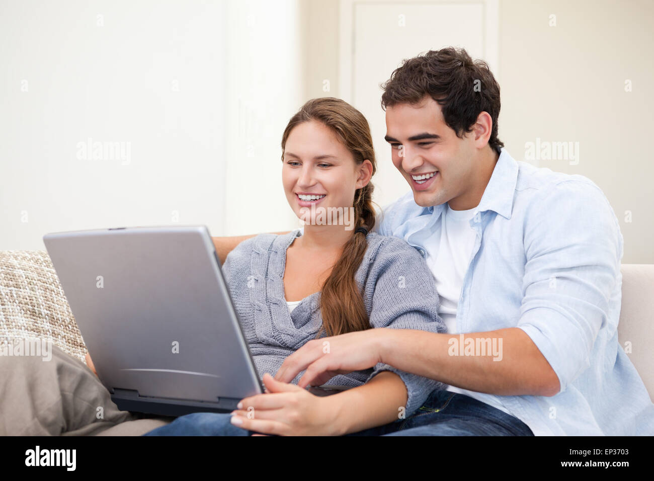 Paar auf einem Sofa sitzend und mit einem laptop Stockfoto