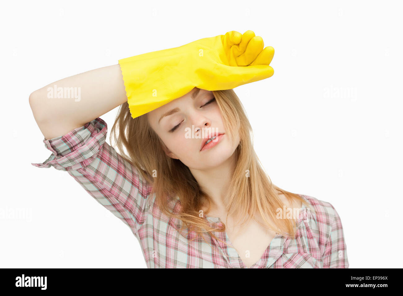 Frau trägt Reinigungshandschuhe beim Abwischen ihre Stirn Stockfoto