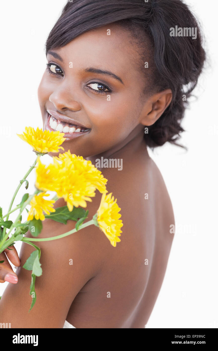Frau auf der Suche über die Schulter hält Blumen Stockfoto