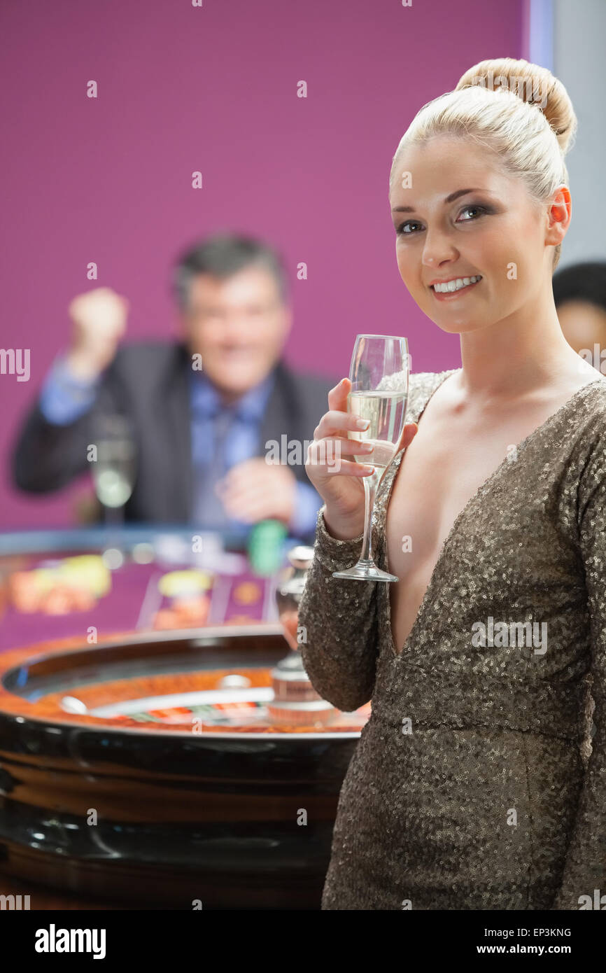 Frau mit Champagner stand neben Roulette-Rad Stockfoto