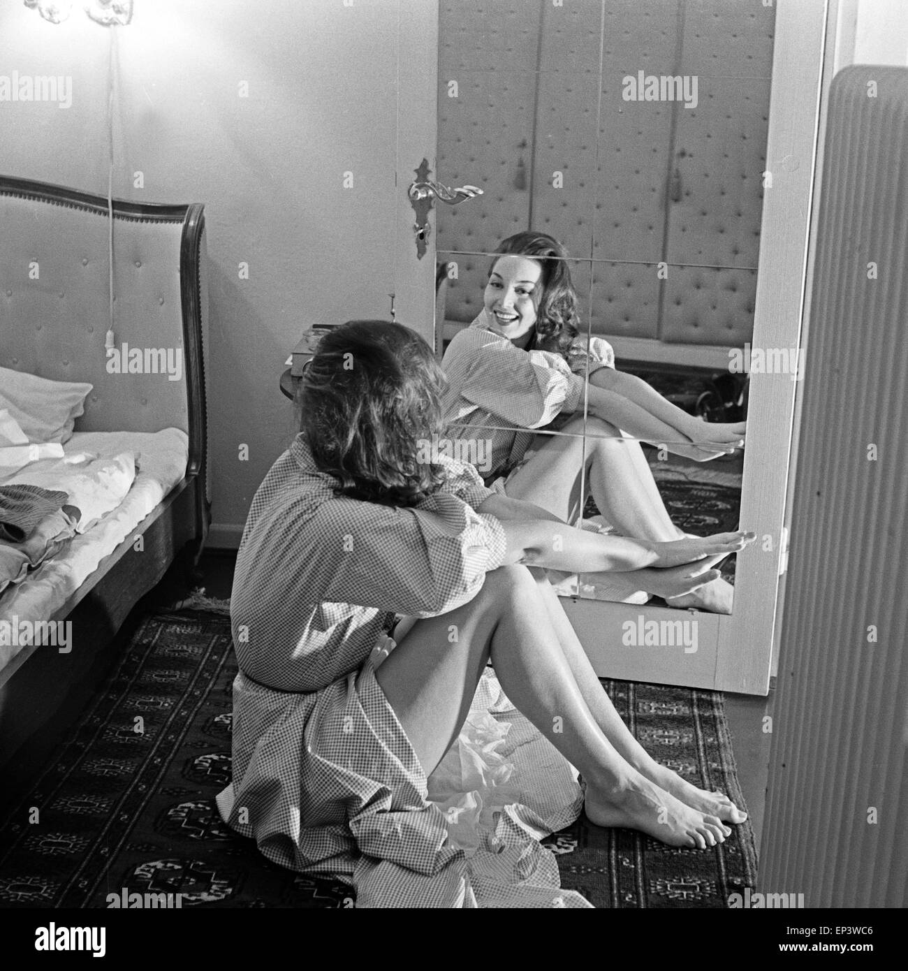 Bei einem Fotoshooting im Studio sitzt auf dem Boden vor einem Spiegel, Deutschland 1950er Jahre. Eine fördernde tun Stockfoto