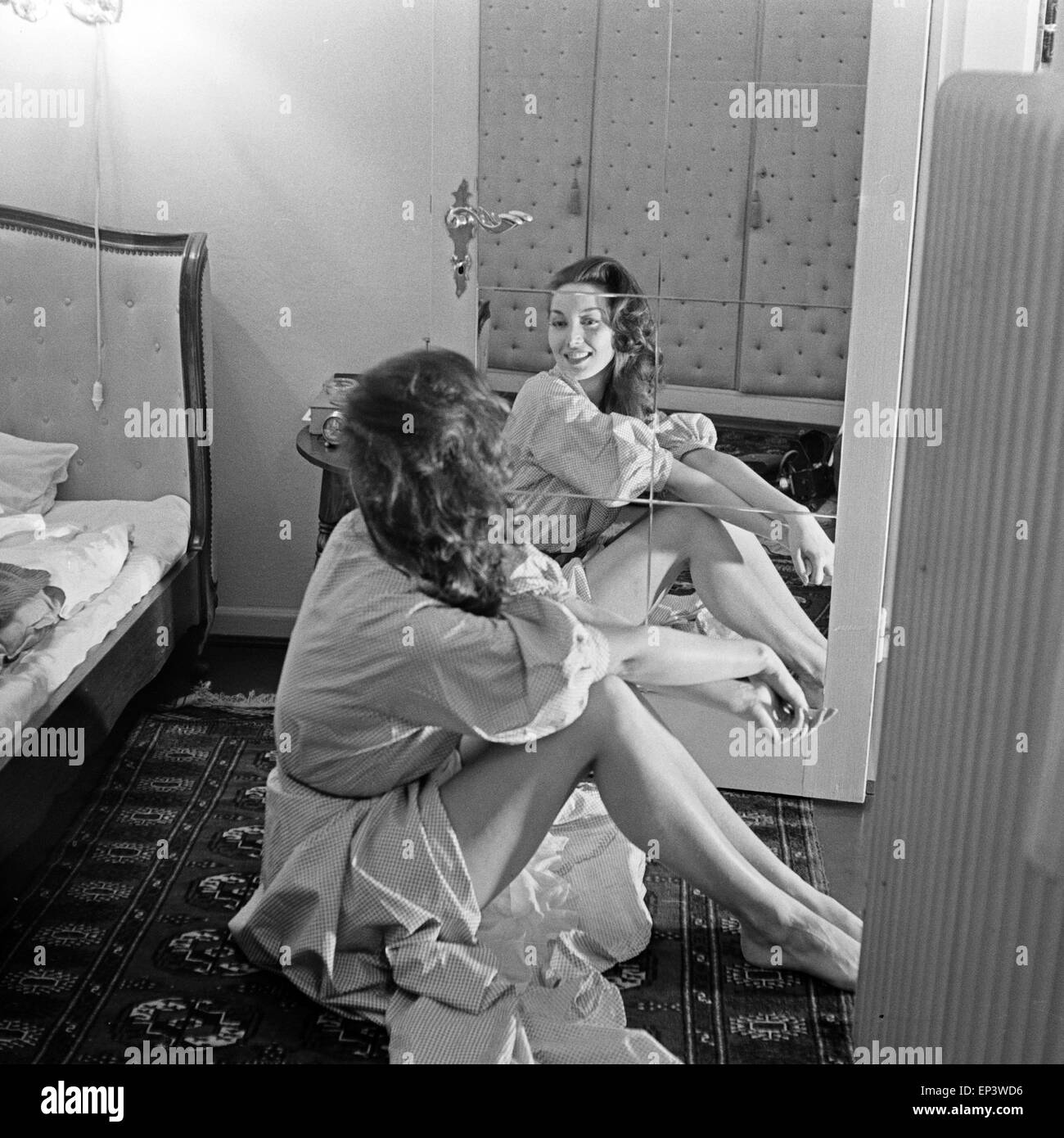 Bei einem Fotoshooting im Studio sitzt auf dem Boden vor einem Spiegel, Deutschland 1950er Jahre. Eine fördernde tun Stockfoto