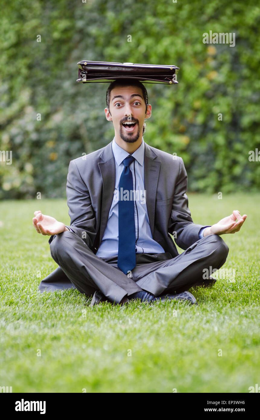 Junger Geschäftsmann meditieren im Garten Stockfoto