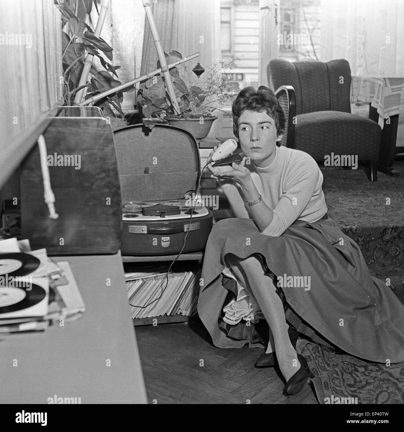 Die deutsche Schlagersängerin Melitta Berg mit einem Mikrofon und einem Tonbandgerät sitzt auf dem Boden im Wohnzimmer, Deutschl Stockfoto