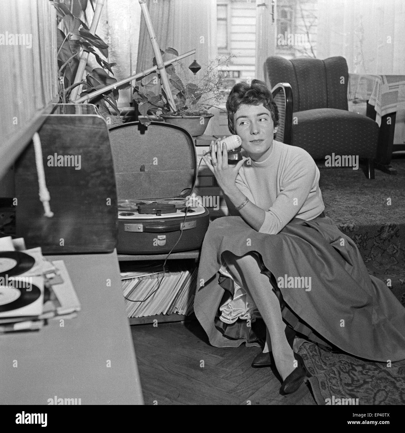 Die deutsche Schlagersängerin Melitta Berg mit einem Mikrofon und einem Tonbandgerät sitzt auf dem Boden im Wohnzimmer, Deutschl Stockfoto